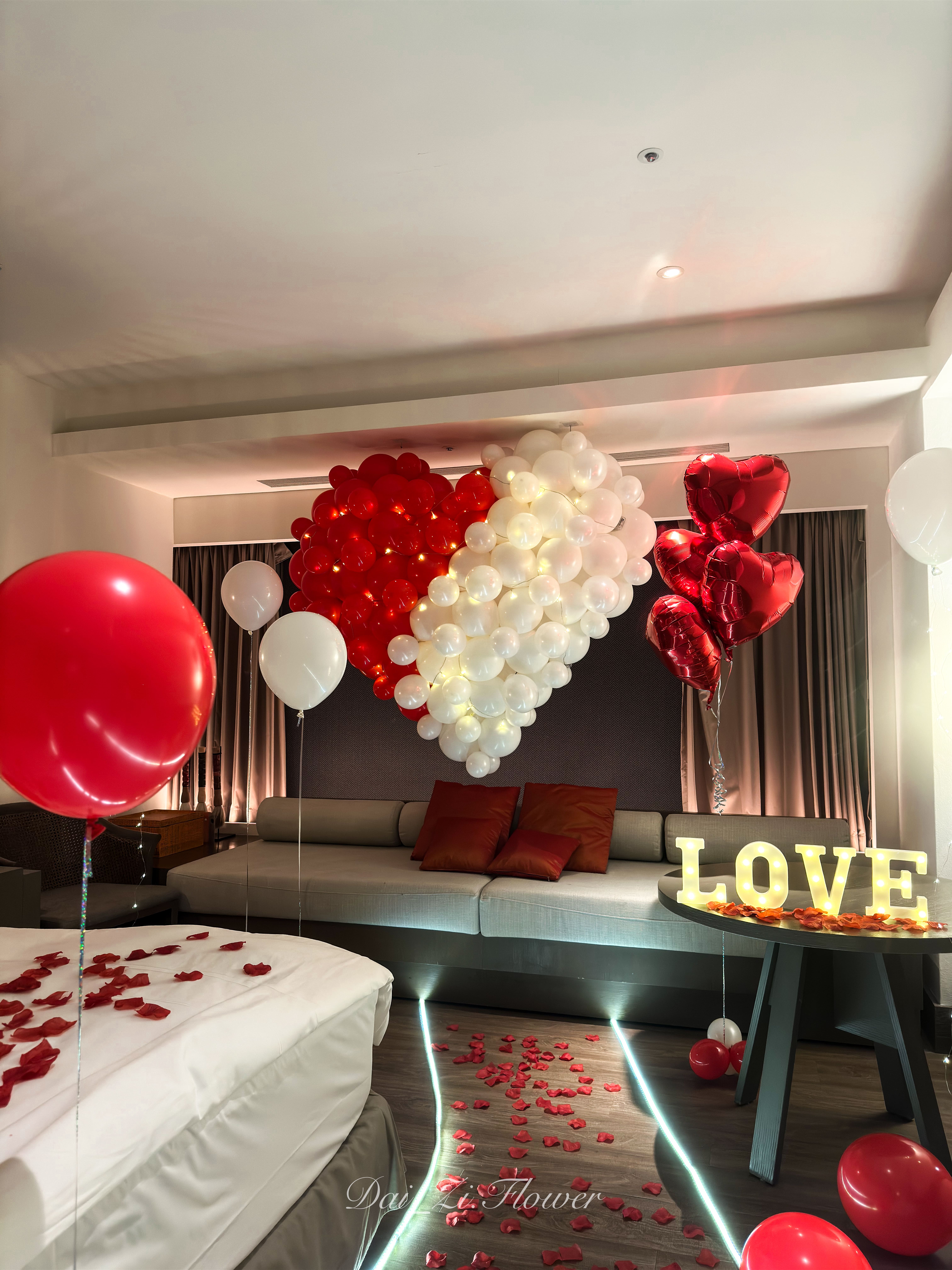 求婚步道佈置，LED燈條搭配紅色花瓣引導至LOVE發光字體桌面。