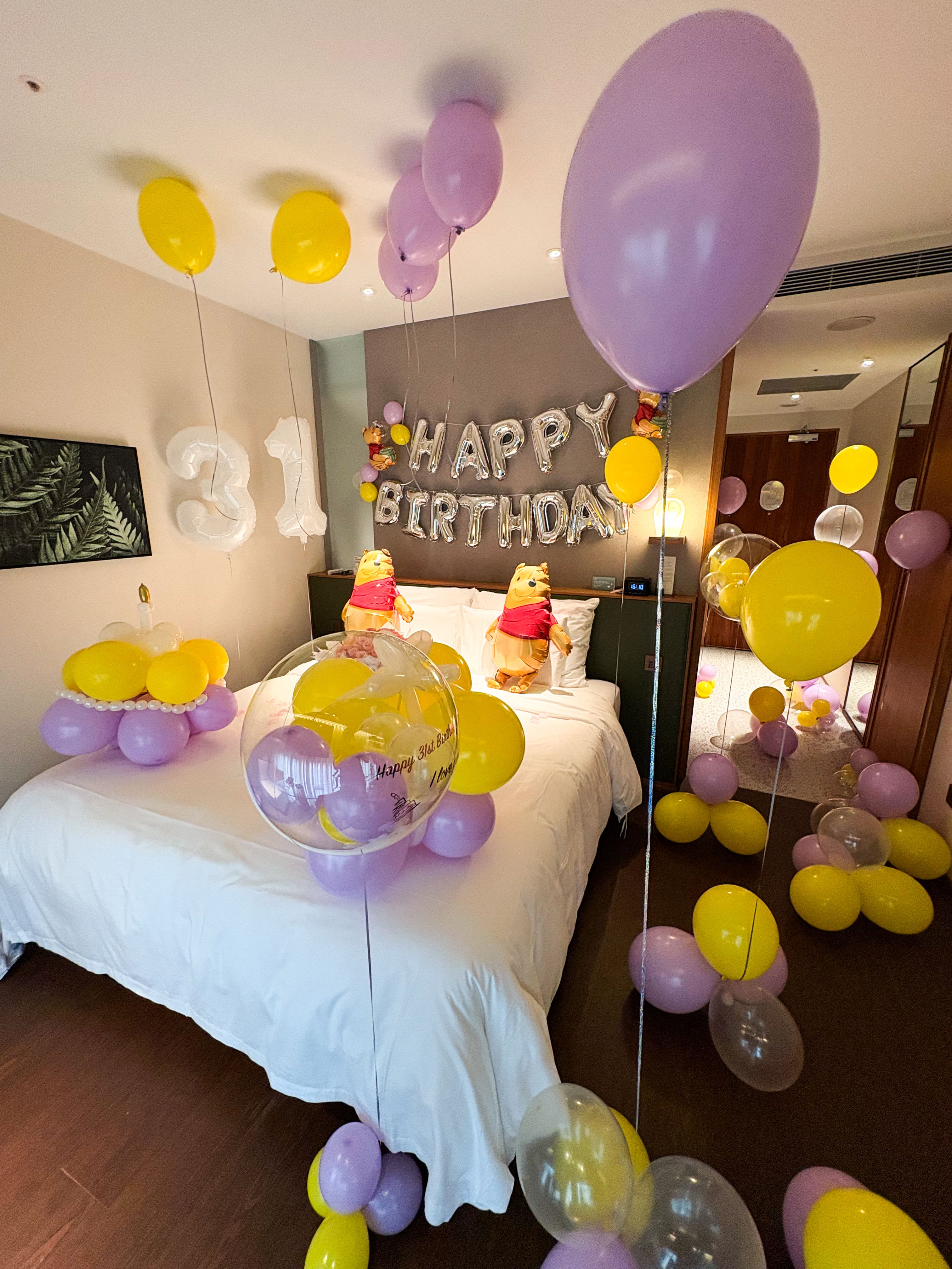 31歲生日飯店氣球佈置，結合維尼熊造型氣球與精緻花束，代紫花藝打造專屬浪漫