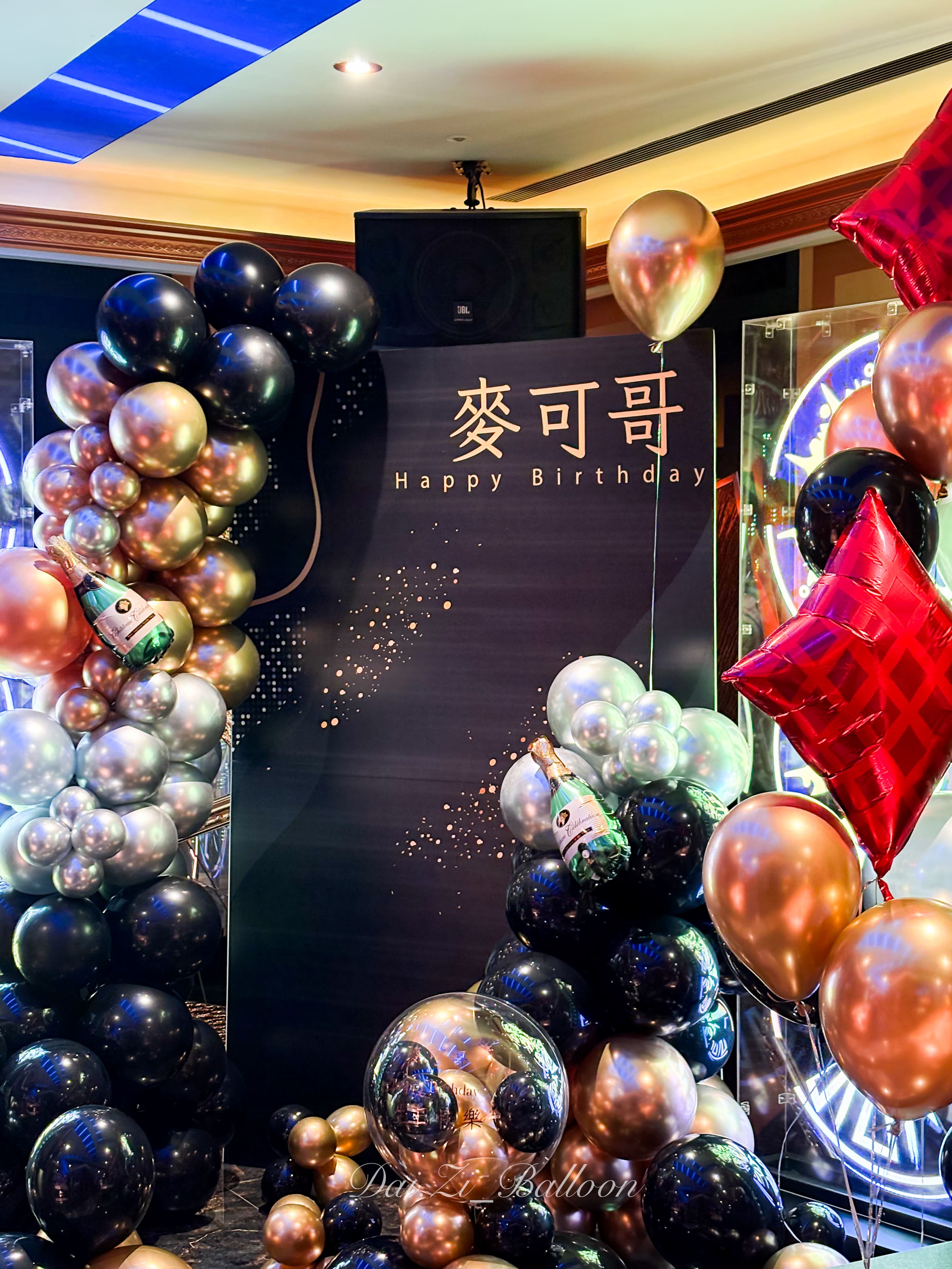 精品生日派對背板細節，黑金銀金屬色氣球鏈搭配立體香檳酒瓶氣球，打造奢華視覺焦點。