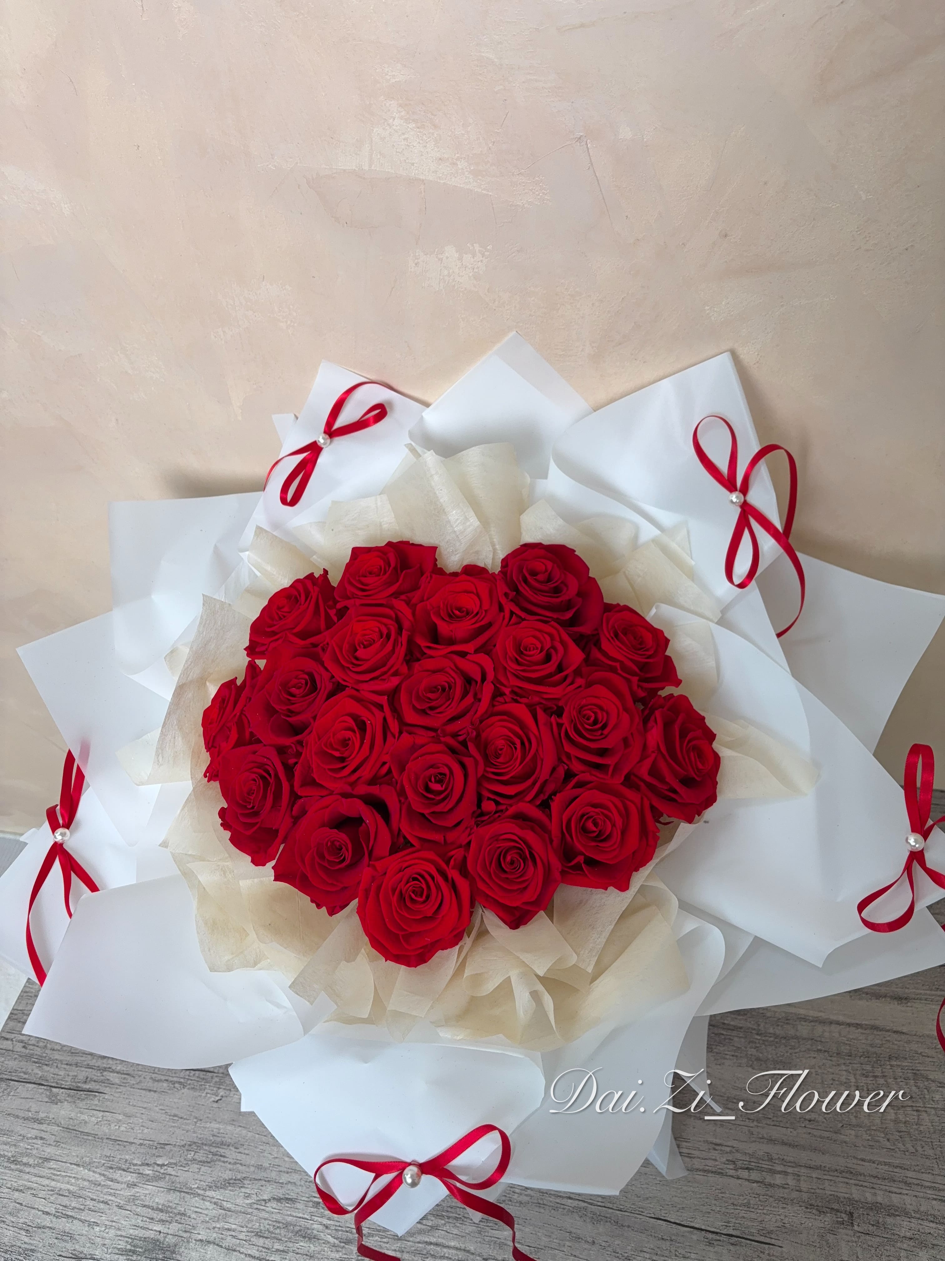 DAIZI代紫花藝-經典紅玫瑰精品花束俯視圖，搭配多層次質感白色包裝與紅色緞帶，大台北地區客製化求婚花束與浪漫告白花禮推薦。