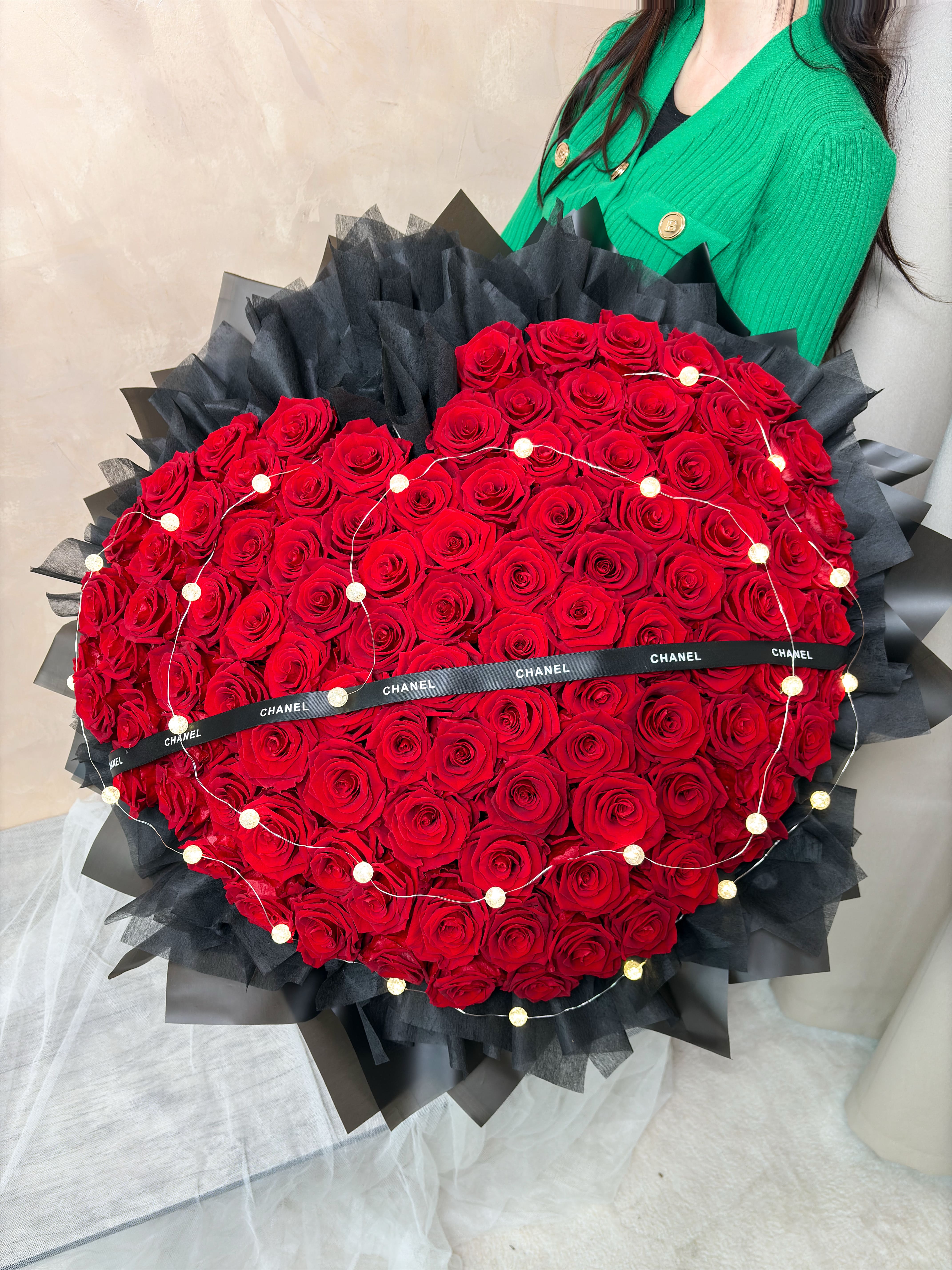 DAIZI代紫花藝-手持巨型100朵永生玫瑰花束展示，飽滿心型紅玫瑰展現極致霸氣與奢華視覺質感，適合大台北地區追求震撼效果的專屬客製化求婚花禮。