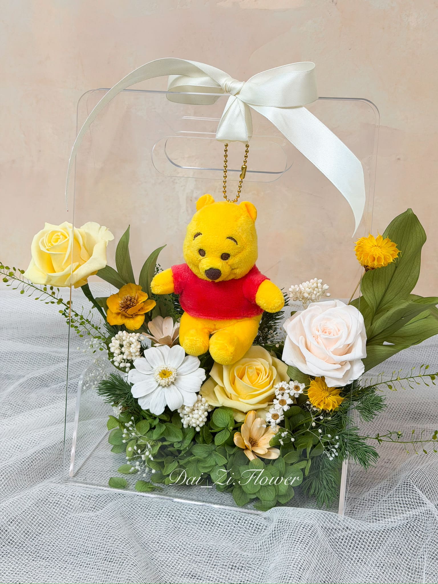 精品級黃、白色系永生花與精緻維尼娃娃近觀特寫，質感透明提盒完美襯托溫暖療癒風格，大台北地區提供全客製化高級驚喜送禮推薦DAIZI代紫花藝。