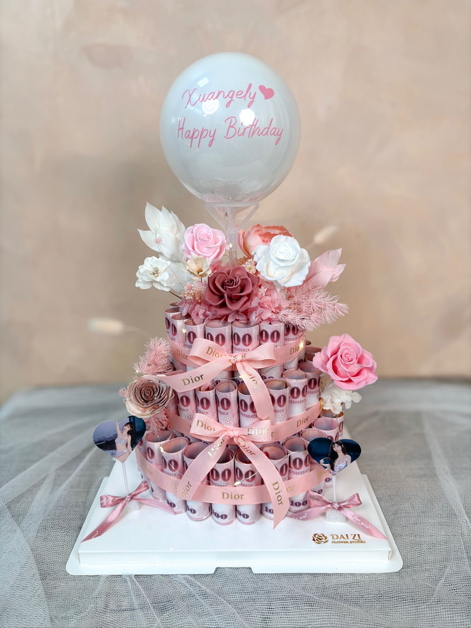 DAI ZI FLOWER STUDIO 代紫花藝全客製化永生花鈔票蛋糕，三層百元鈔票打造精緻有錢花造型，搭配專屬印字氣球與頂級粉色系永生玫瑰，是生日驚喜與紀念日的最佳浪漫禮物選擇。