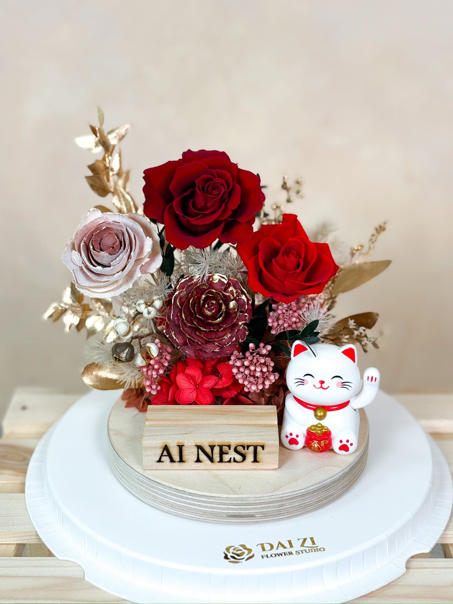 DAIZI 代紫花藝全客製化永生花名片座，結合紅金色系頂級玫瑰與開運招財貓，是大台北精品門市開幕送禮與櫃檯佈置的高質感首選。