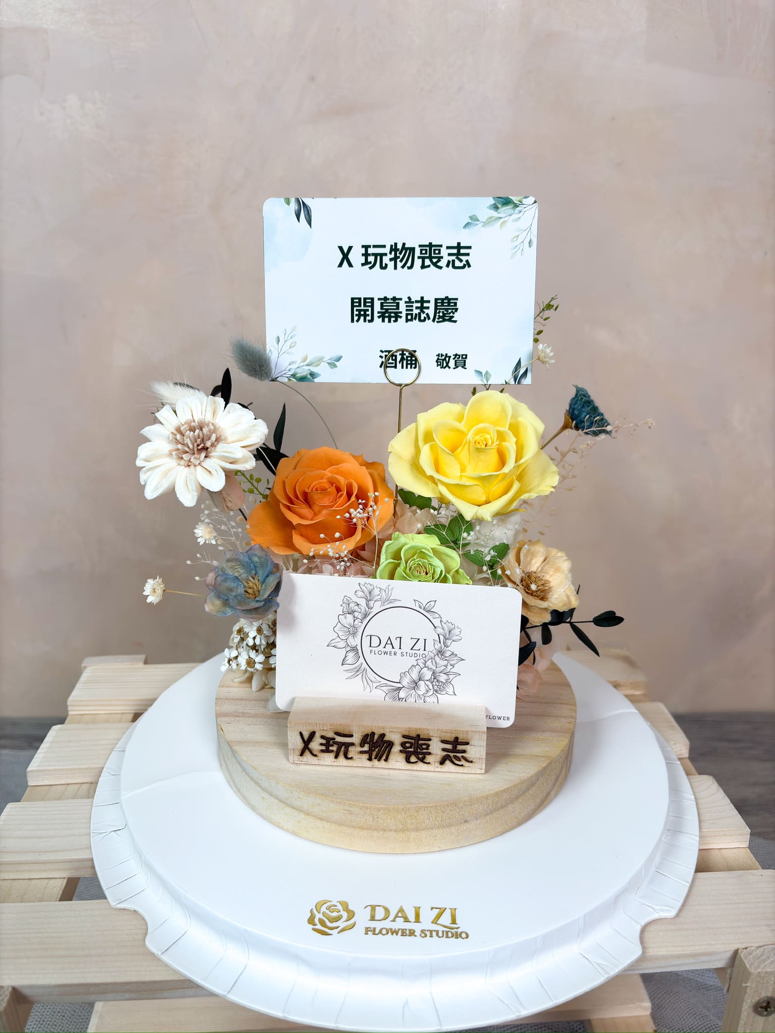 DAIZI 代紫花藝為品牌「X玩物喪志」專屬訂製永生花名片座，活力橘黃配色結合精品花藝，展現品牌個性的開幕送禮與櫃檯佈置。