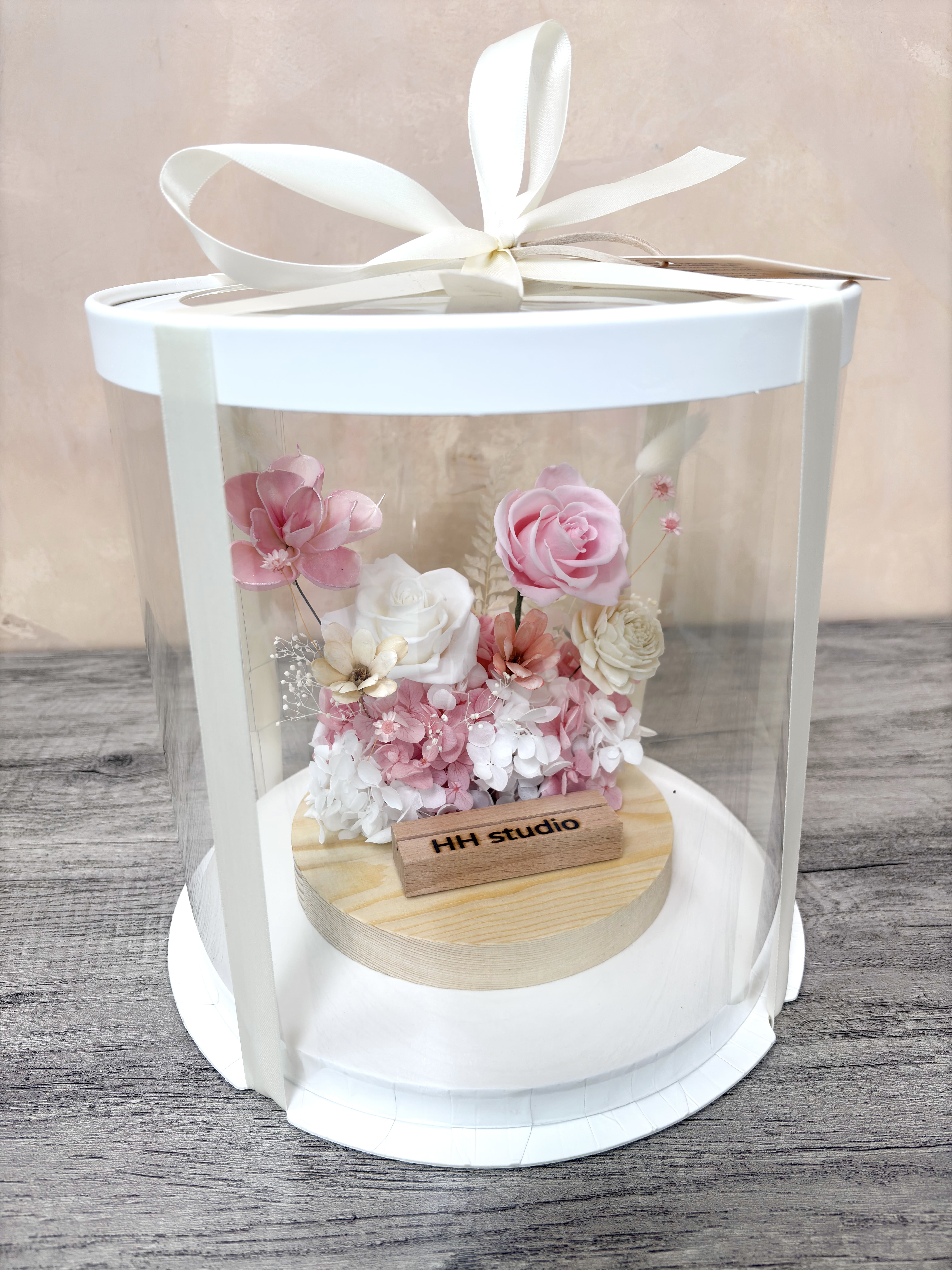 大台北精品客製化花禮首選，DAIZI代紫花藝設計之永生花名片座，精緻白緞帶封裝禮盒讓開幕送禮誠意滿分，為商業空間櫃檯注入清新優雅的藝術氛圍。