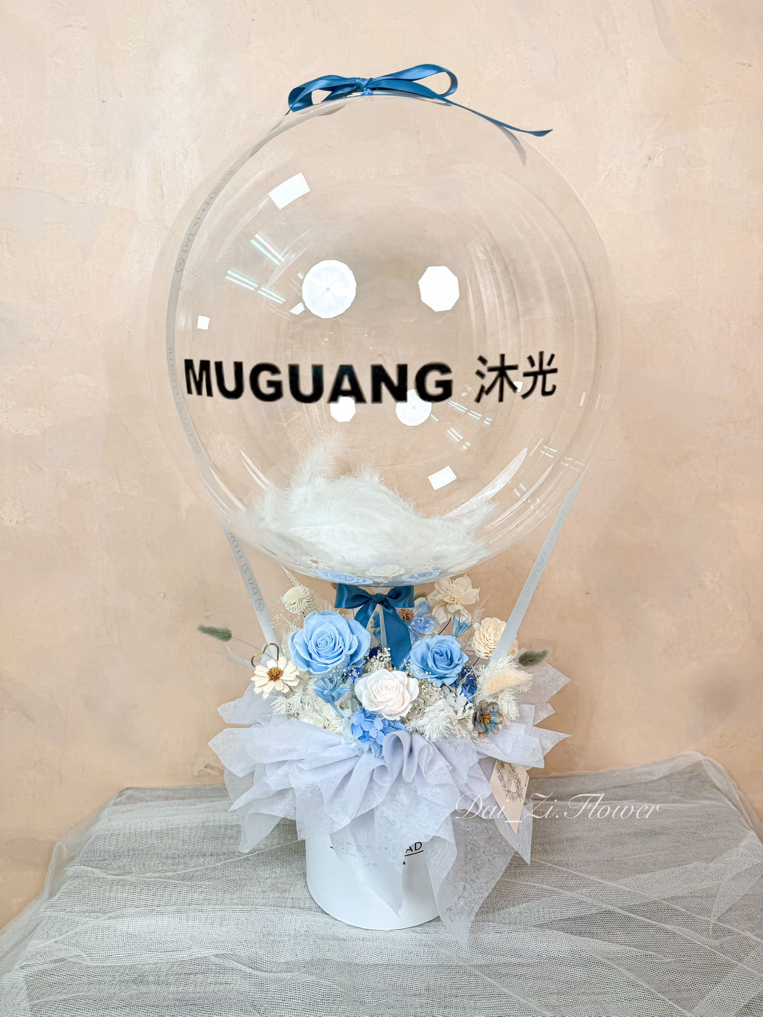 DAIZI代紫花藝為 MUGUANG 沐光 專屬訂製之開幕送禮熱氣球花禮，清新藍白系永生花搭配精品波波球，提升商業空間櫃檯的高質感美學。