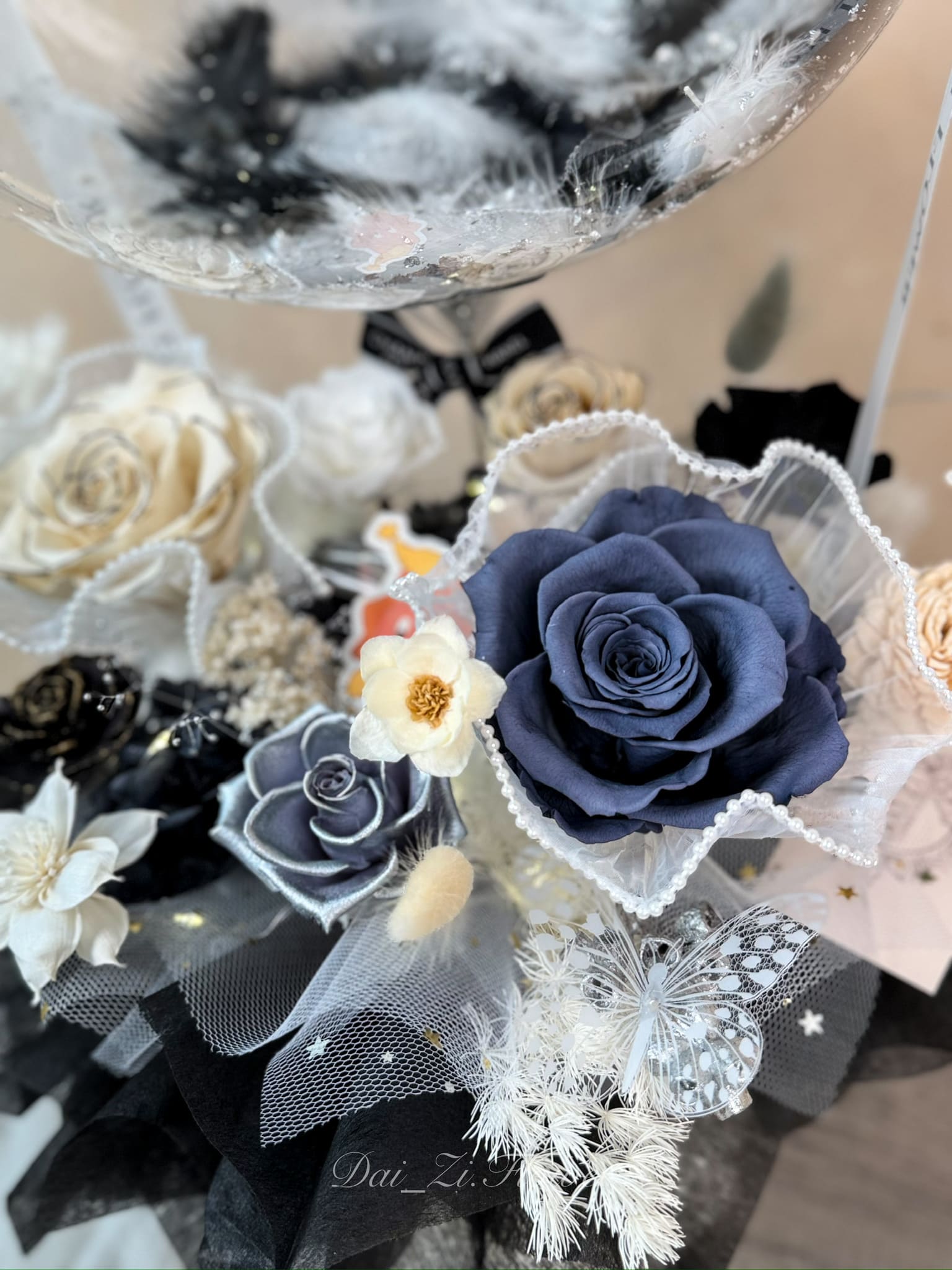 精品級永生花設計：深藍色永生玫瑰搭配立體蝴蝶與珠珠蕾絲，DAIZI 代紫花藝提供專業且細膩的花藝佈置服務。
