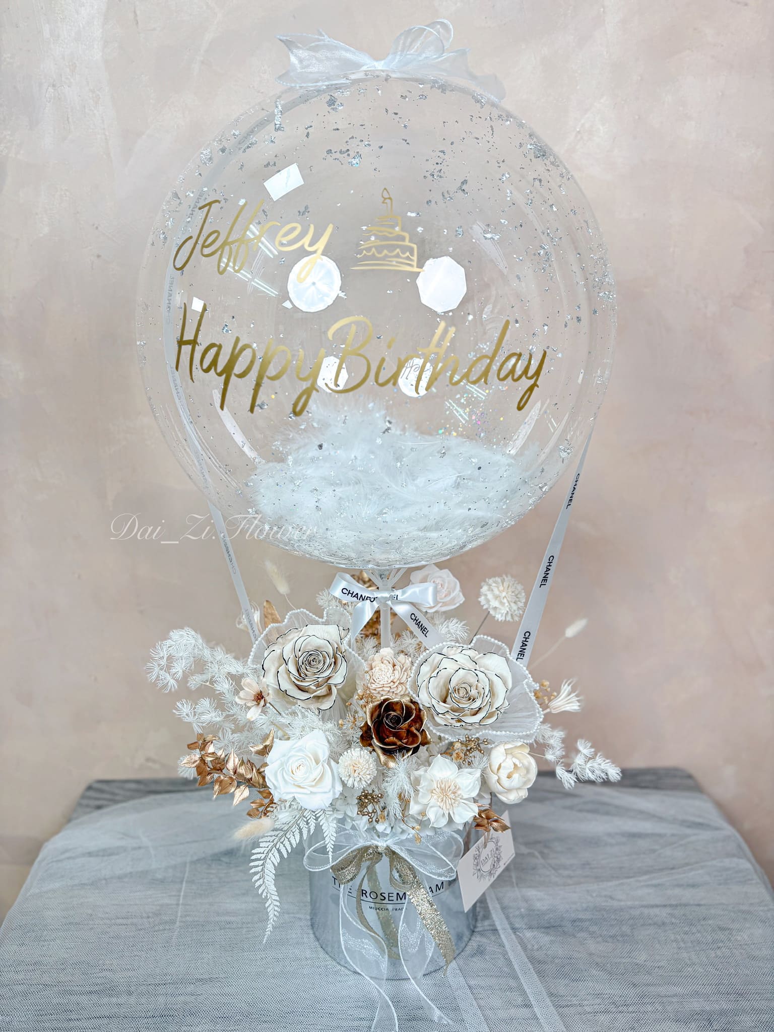 📍 客製化波波球花禮：精品黑白金系永生花抱抱桶，氣球噴印 Happy Birthday 金色字體並搭配銀色亮片羽毛，適合台北驚喜佈置。