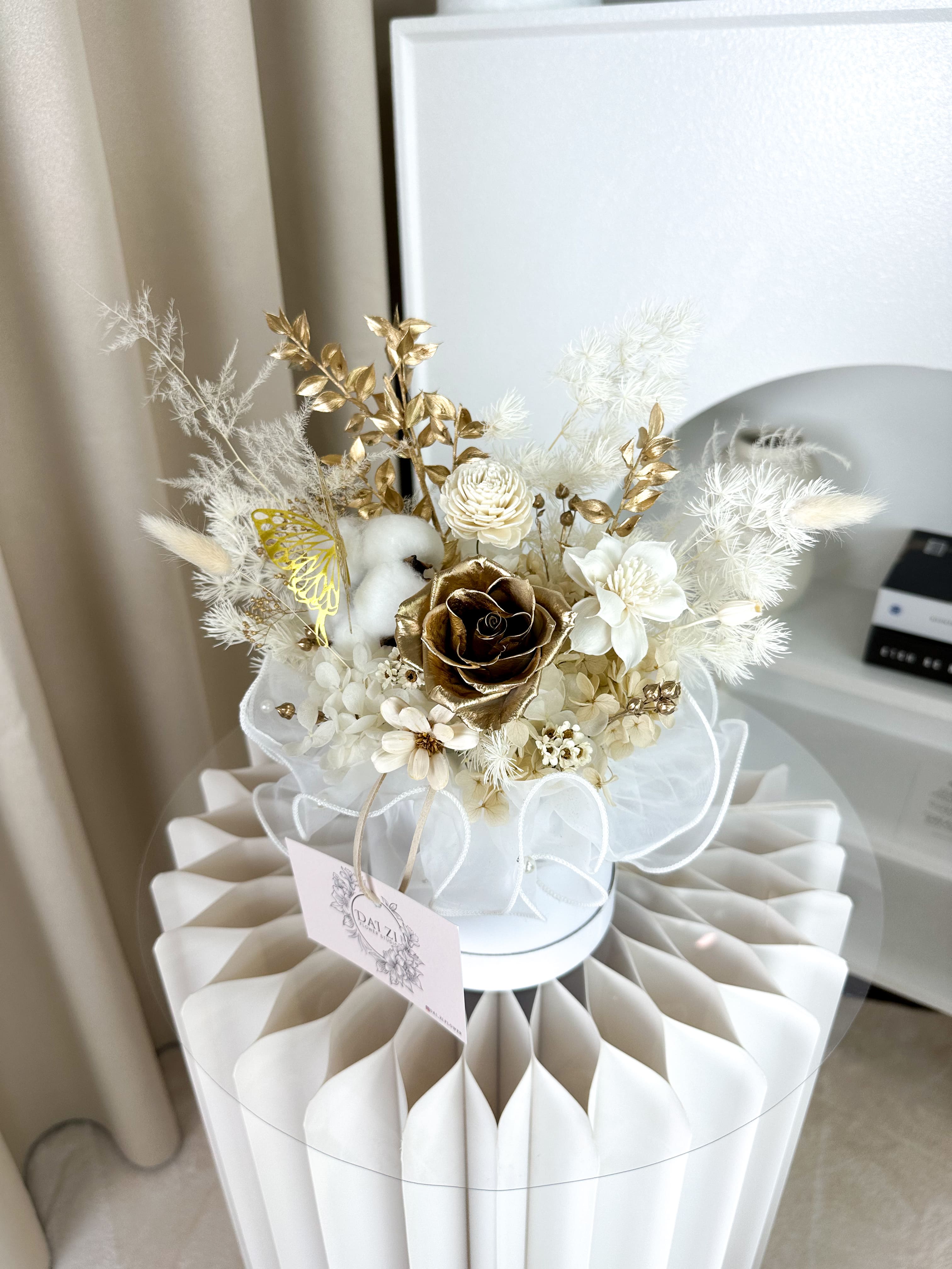 台北代紫花藝精品永生花抱抱桶，金色系玫瑰與米白花材設計，高品質開幕祝賀與週年紀念驚喜禮物推薦。