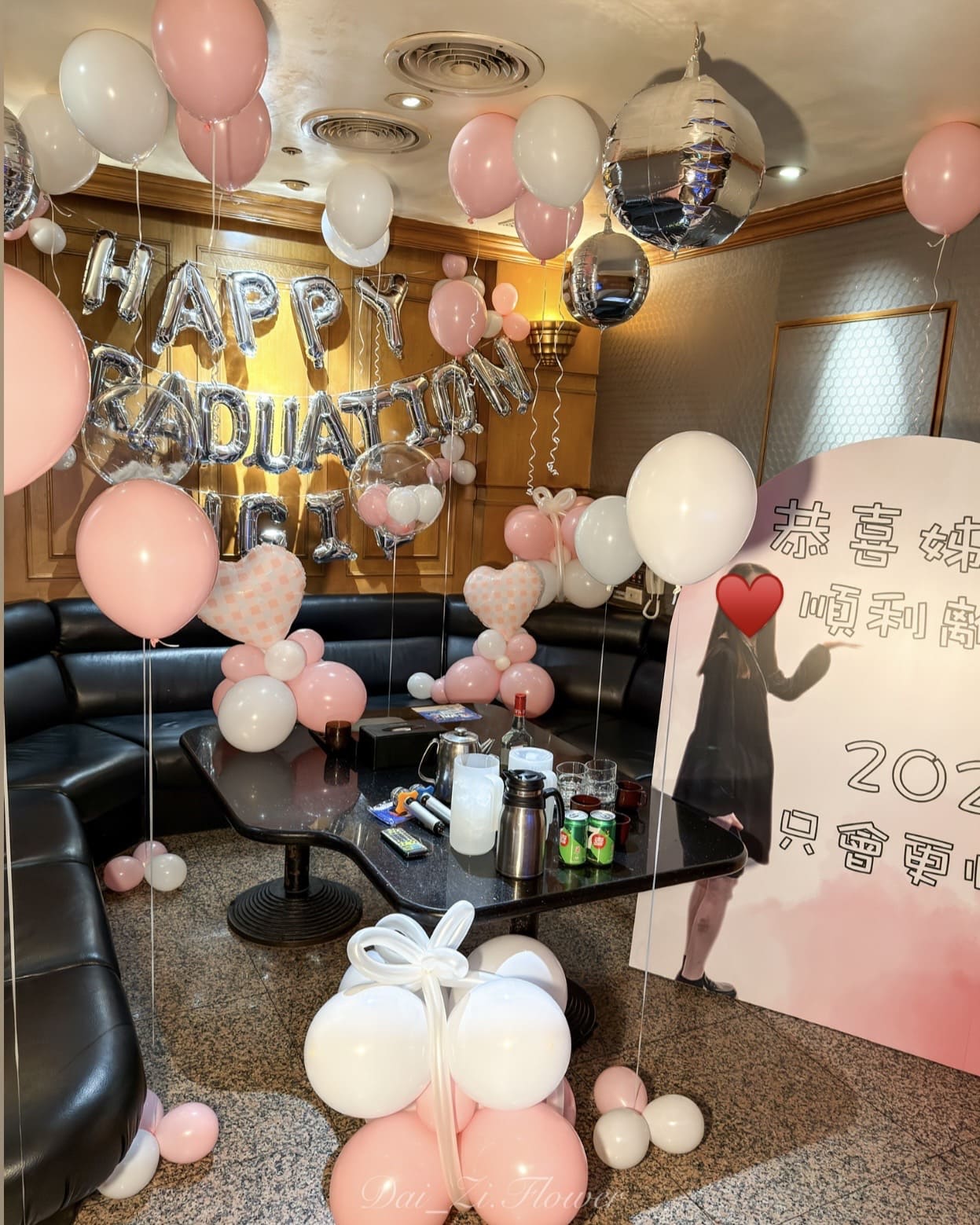 台北畢業氣球佈置推薦 DAIZI代紫花藝：粉白色系畢業驚喜佈置含客製化照片背板與禮物造型氣球。