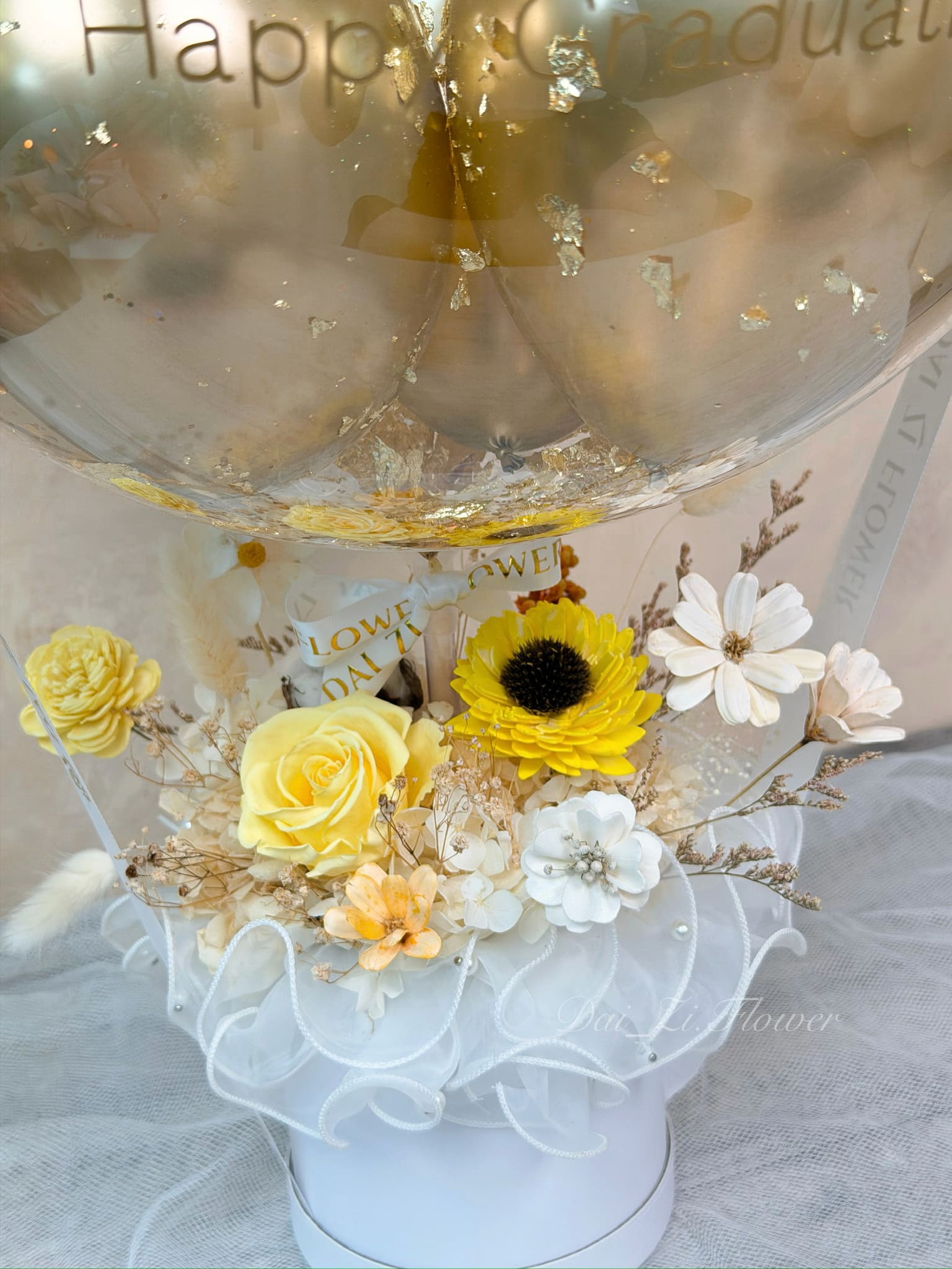 精品級畢業永生花迷你抱抱桶花材細節，頂級黃色永生玫瑰搭配向日葵與法式白紗設計，台北客製化花店推薦代紫花藝