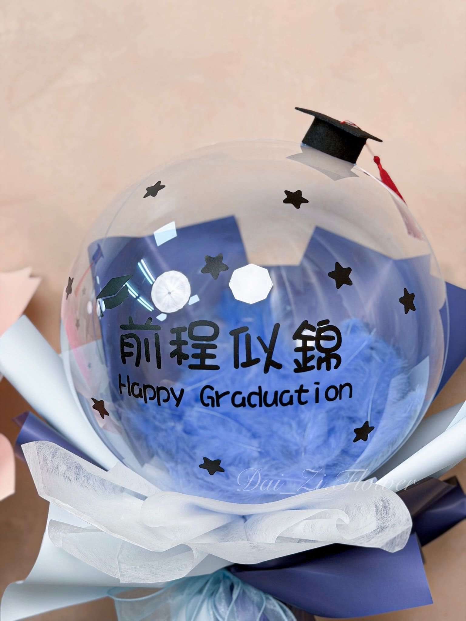高質感客製化波波球特寫，粉色羽毛氣球搭配我們畢業了標語，台北精緻畢業花店代紫花藝