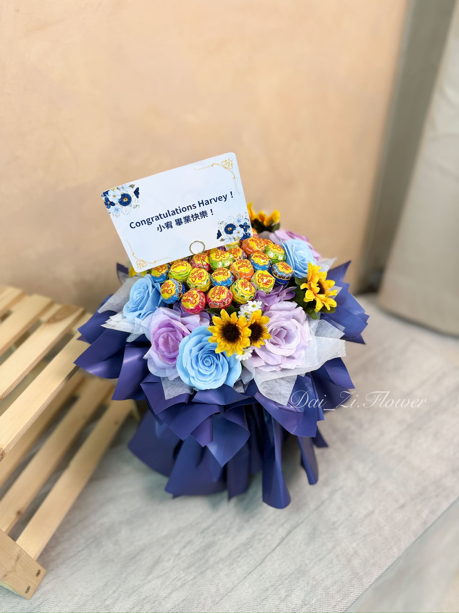 台北畢業花束推薦：DAIZI代紫花藝【甜夢星球】棒棒糖畢業花束，結合客製化畢業賀卡設計，嚴選高質感藍紫甦醒香氛花與仿真向日葵，雙北地區創意畢業禮物精品首選。