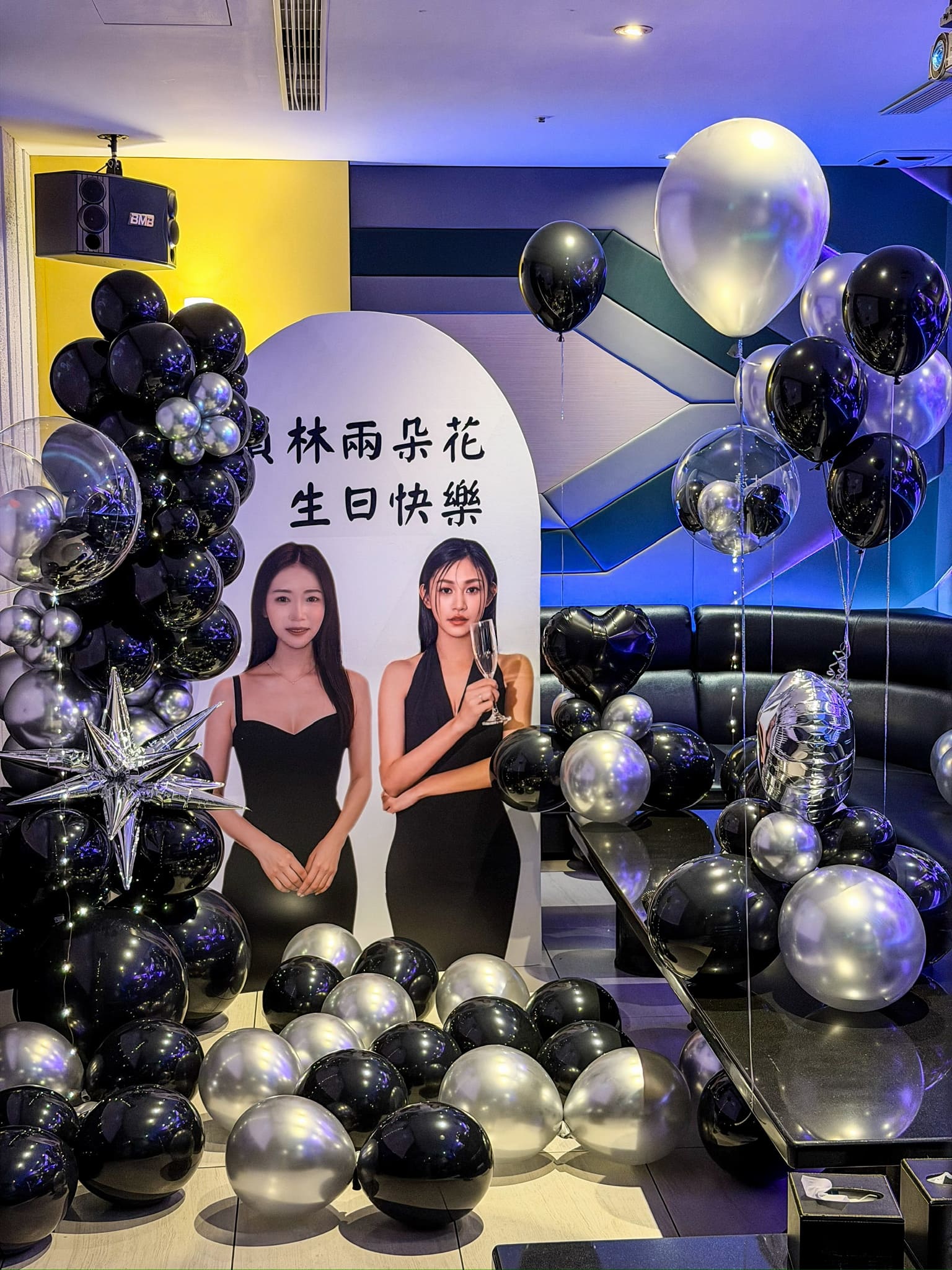 台北高單價KTV包廂佈置推薦，客製化人形背板結合黑銀色系氣球藝術，打造精品級雙人生日驚喜代紫花藝
