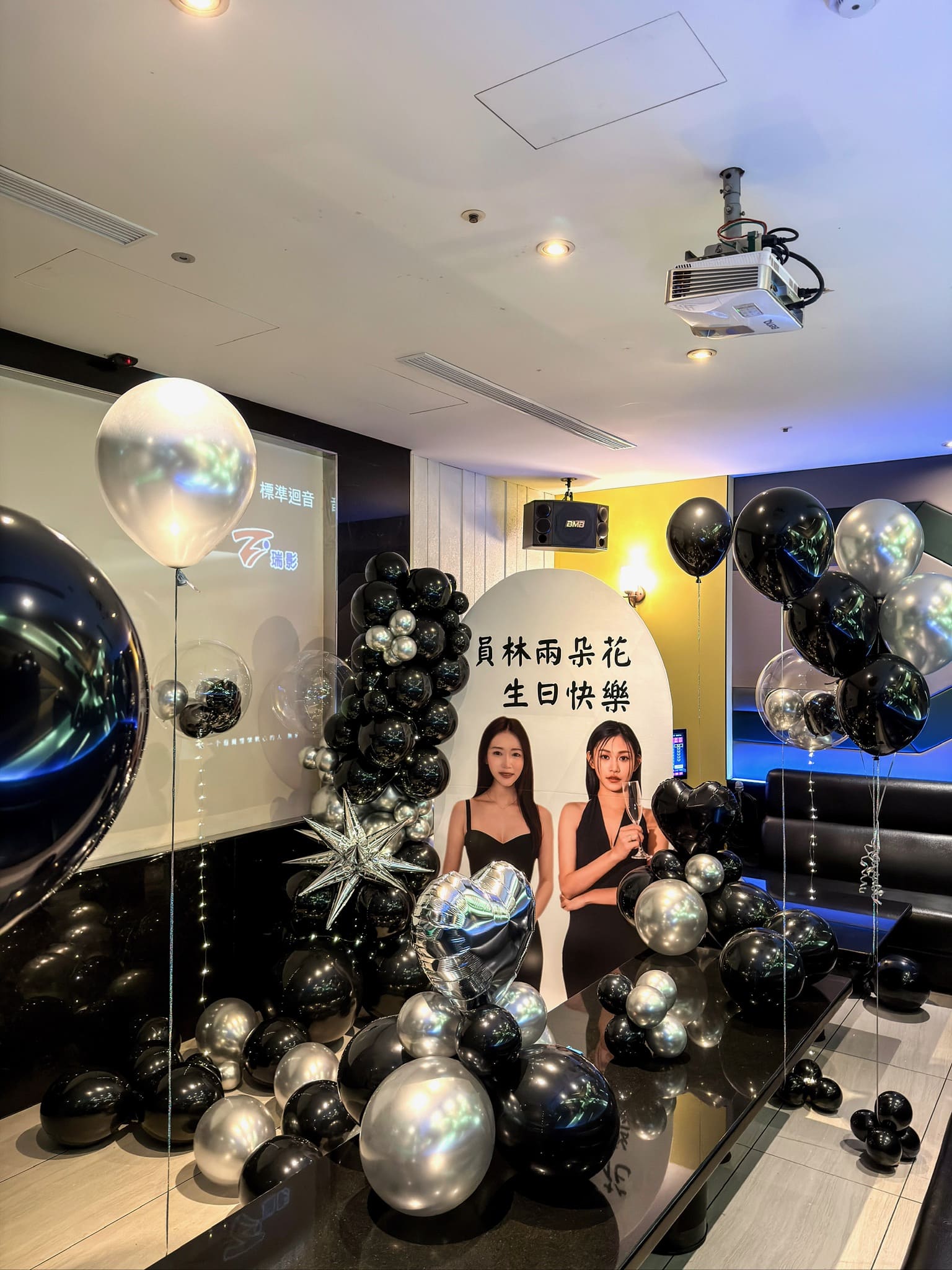 台北派對佈置推薦，客製化雙人壽星人形立牌搭配黑銀色氣球柱與空飄氣球，高質感KTV慶生設計代紫花藝