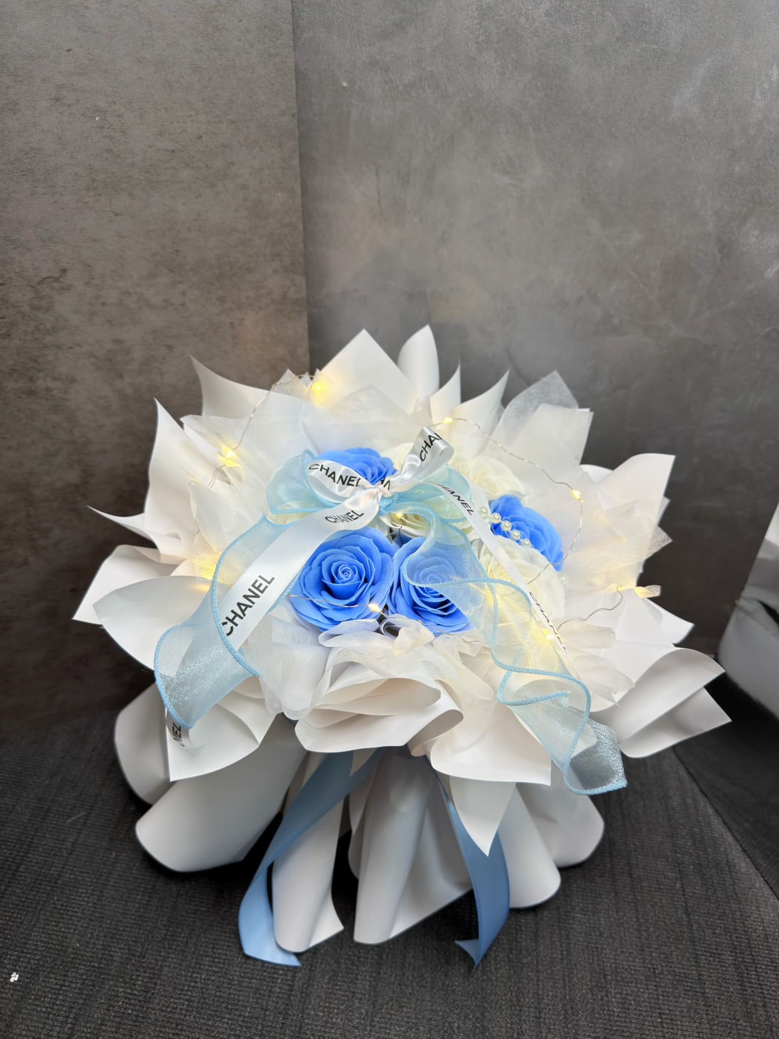 新北生日送禮推薦：DAIZI代紫花藝冰藍色甦醒玫瑰香氛花束，搭配質感緞帶與微光燈串，千元預算打造大台北地區法式簡約風格精品花禮。