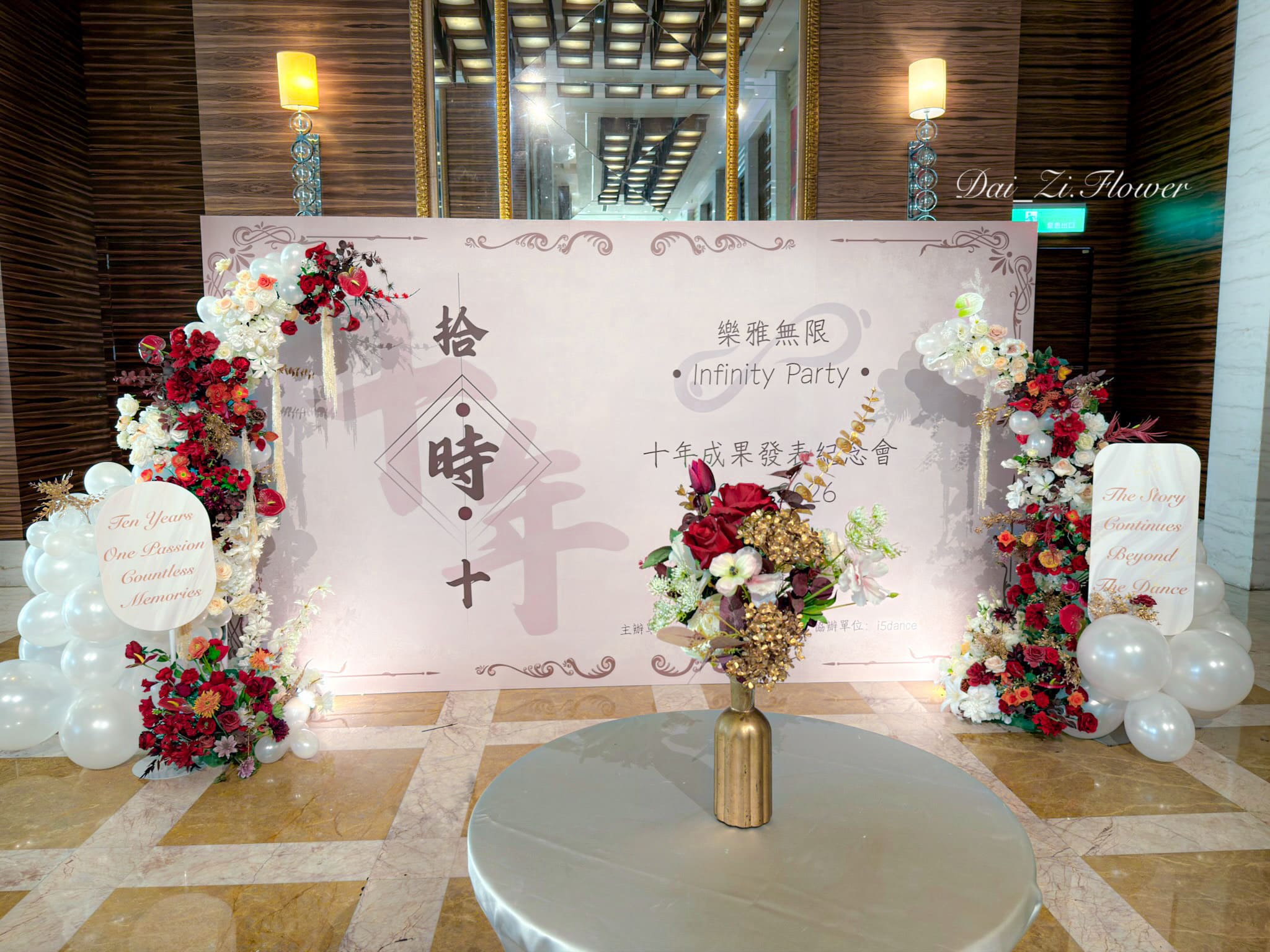 DaiZi 代紫花藝｜大直典華舞蹈成果發表十週年紀念會全景佈置—酒紅白香檳橘色仿真花柱搭配白色有機氣球群與粉紫背板，左右雙側花藝立柱搭配客製文字牌，台北大型活動花藝氣球佈置推薦